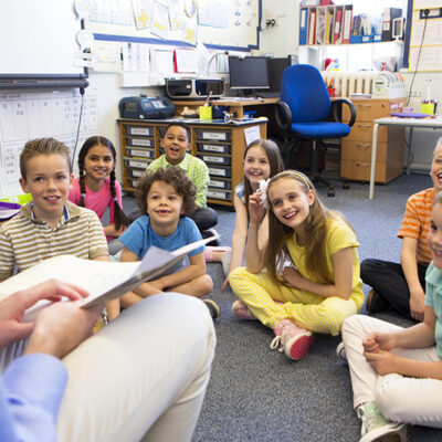 Teacher with Classroom Reading License reading script to younger students