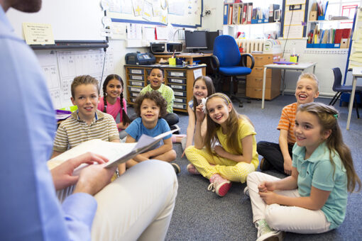 Teacher with Classroom Reading License reading script to younger students